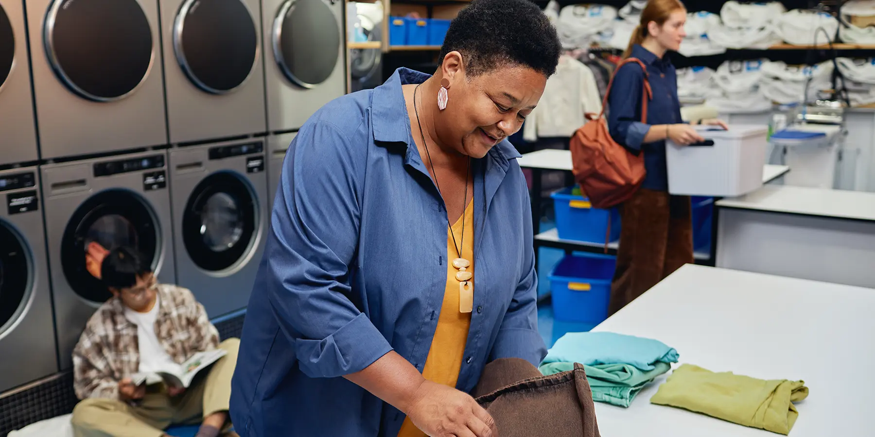 woman folding clothes at laundromat